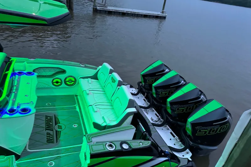 Slide: The Image of 2024 Deep Impact 399 Sport boat with vibrant green interior and four powerful outboard engines. - 3