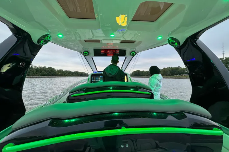 Slide: The Image of 2024 Deep Impact 399 Sport boat interior with green LED lighting on the water. - 5