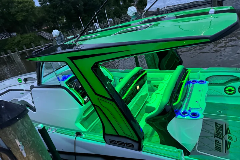 Slide: The Image of 2024 Deep Impact 399 Sport boat with vibrant green interior lighting at a dock. - 7