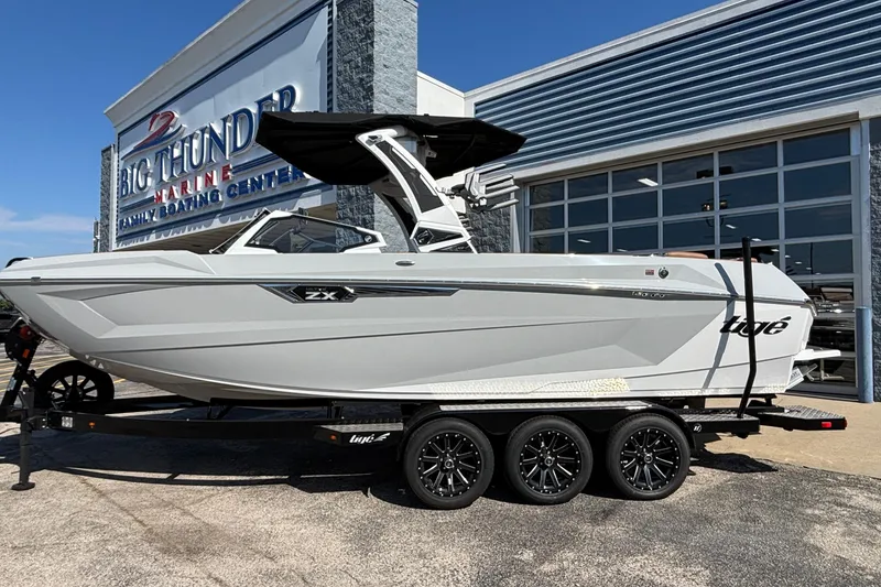 Slide: The Image of 2025 Tigé Ultré 25ZX boat on trailer at Big Thunder Marine dealership. - 2