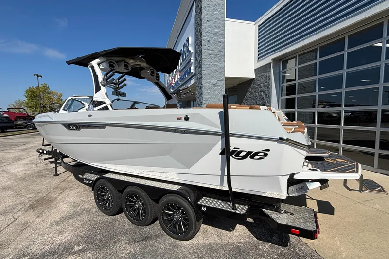 Slide: The Image of 2025 Tigé Ultré 25ZX boat on trailer outside dealership, showcasing sleek design and modern features. - 3