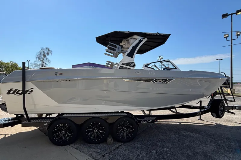 Slide: The Image of 2025 Tigé Ultré 25ZX boat on trailer, sleek design, sunny day background. - 6