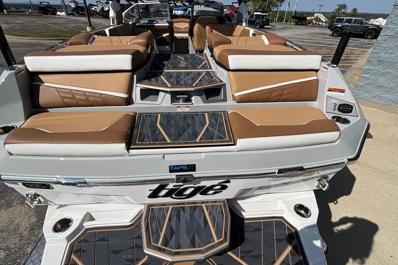 Slide: The Image of 2025 Tigé Ultré 25ZX boat interior with tan and white seating, stylish deck design. - 8