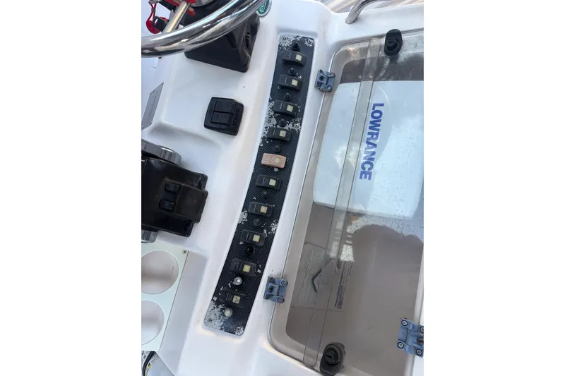 Slide: The Image of 2001 Grady-White Chase 263 boat dashboard with Lowrance equipment and control switches. - 12