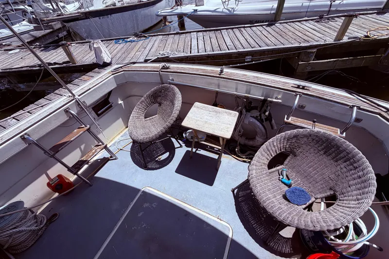 Slide: The Image of 1978 Mainship 34 Trawler deck with wicker chairs and table at marina. - 11
