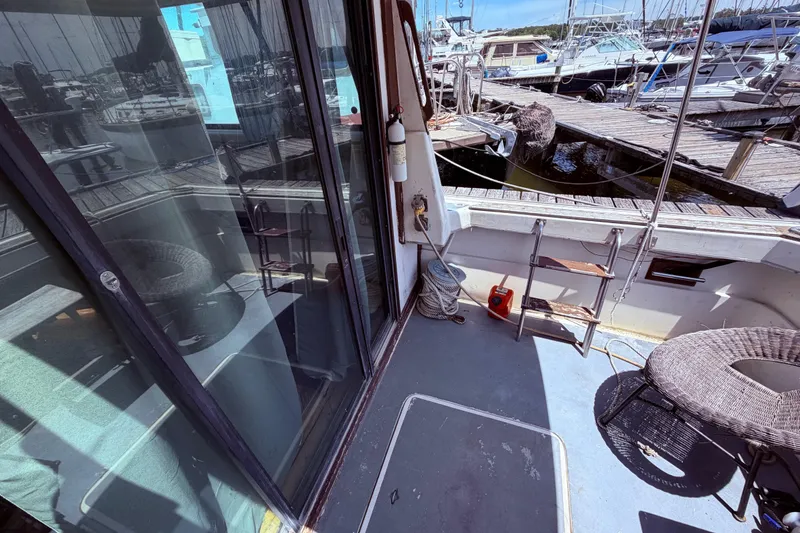Slide: The Image of 1978 Mainship 34 Trawler deck with marina view, featuring seating and nautical equipment. - 12