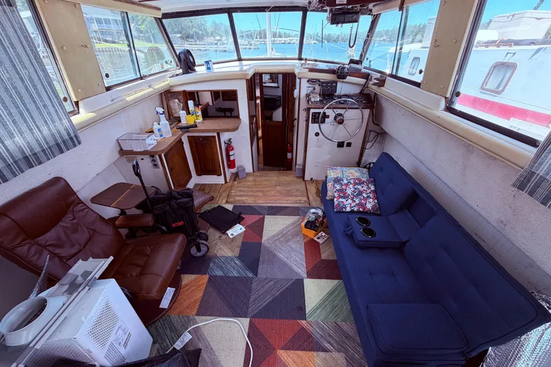 Slide: The Image of Interior of a 1978 Mainship 34 Trawler with seating, helm, and nautical decor. - 15