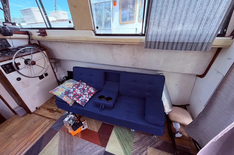 Slide: The Image of Interior of a 1978 Mainship 34 Trawler with blue sofa and nautical decor. - 16