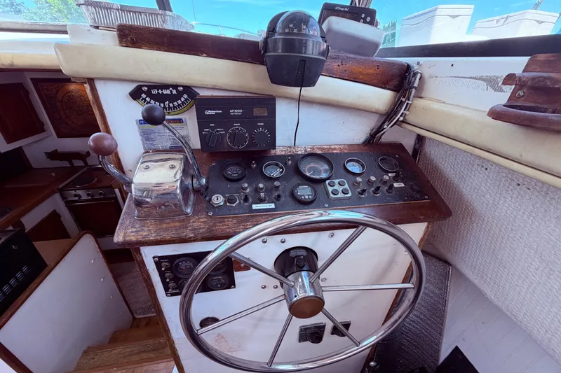 Slide: The Image of 1978 Mainship 34 Trawler helm with vintage controls and steering wheel. - 22