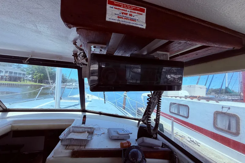 Slide: The Image of Interior view of a 1978 Mainship 34 Trawler, showcasing navigation equipment and marina surroundings. - 23