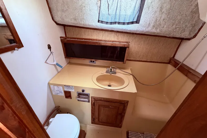 Slide: The Image of 1978 Mainship 34 Trawler bathroom with sink, toilet, and shower area. - 26