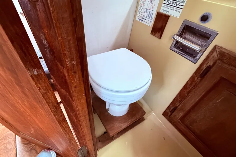 Slide: The Image of 1978 Mainship 34 Trawler bathroom with wooden accents and compact toilet. - 28