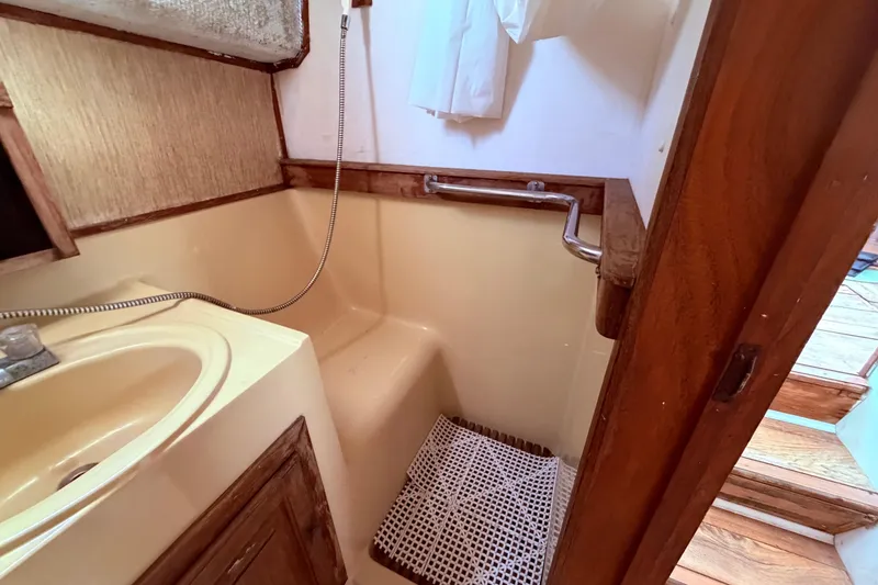 Slide: The Image of 1978 Mainship 34 Trawler bathroom with sink, shower, and wooden accents. - 29