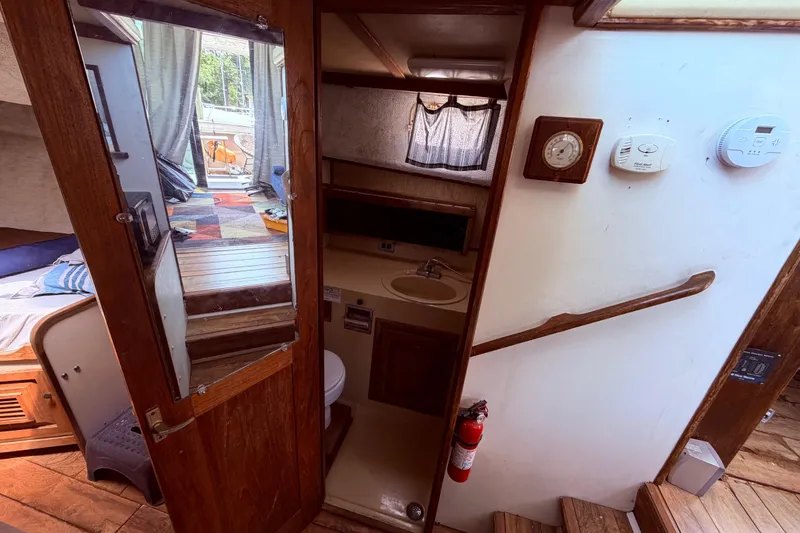 Slide: The Image of Interior of 1978 Mainship 34 Trawler, featuring a compact bathroom and cozy cabin space. - 34