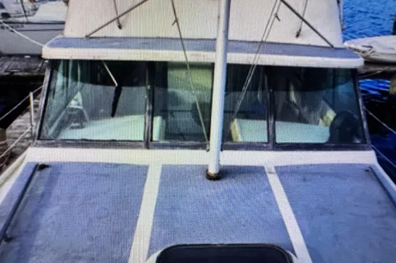 Slide: The Image of 1978 Mainship 34 Trawler docked, showcasing front deck and cabin windows. - 4