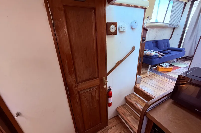 Slide: The Image of Interior of 1978 Mainship 34 Trawler with wooden door, stairs, and cozy seating area. - 43