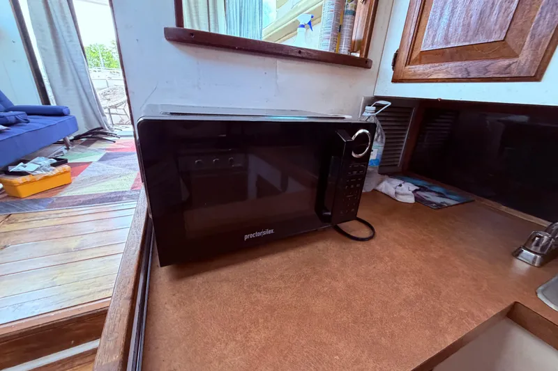 Slide: The Image of Microwave on Mainship 34 Trawler's wooden countertop, 1978 model interior. - 51