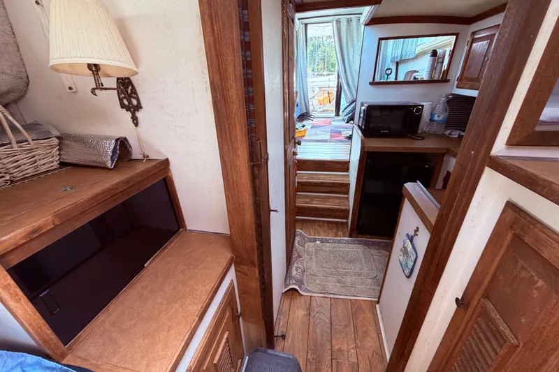 Slide: The Image of Interior of a 1978 Mainship 34 Trawler with wooden cabinetry and compact kitchen area. - 52