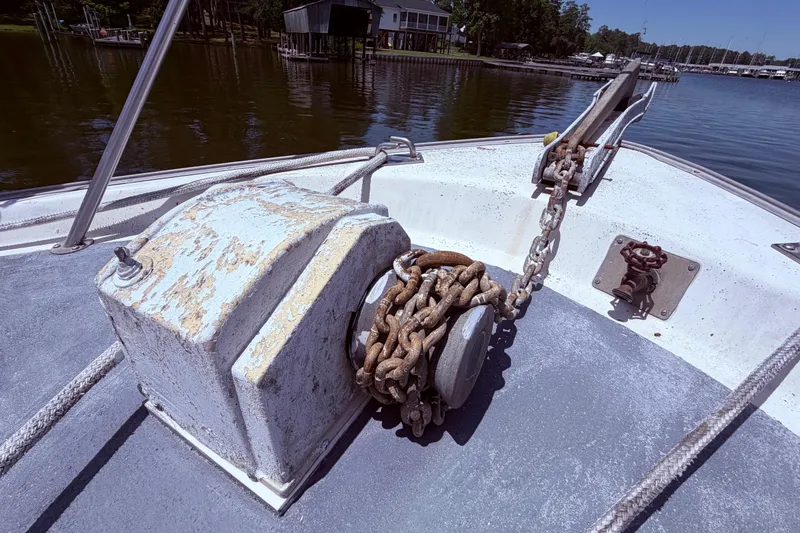 Slide: The Image of 1978 Mainship 34 Trawler anchor chain on deck, docked by a serene lake. - 6