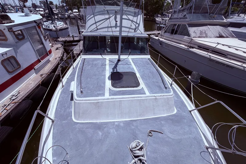 Slide: The Image of 1978 Mainship 34 Trawler docked at marina, showcasing deck and surrounding boats. - 8