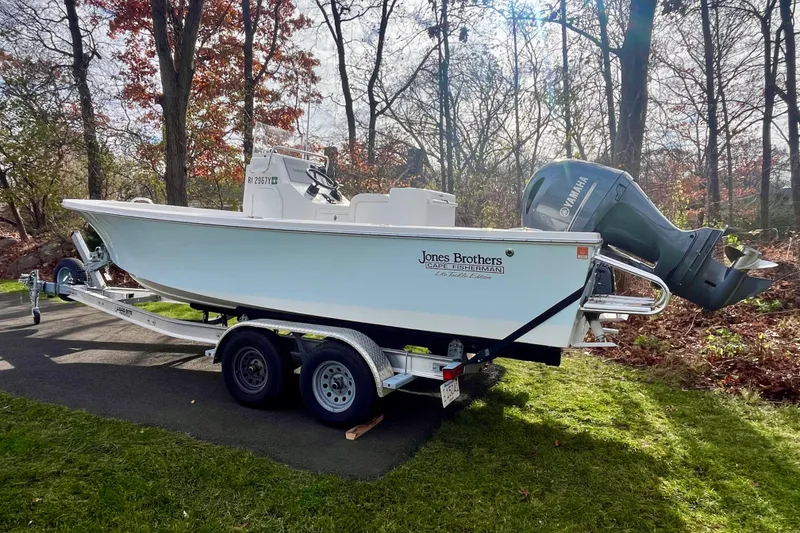 Slide: The Image of 2023 Jones Brothers 23 Cape Fisherman Lite Tackle boat on trailer in wooded area. - 27