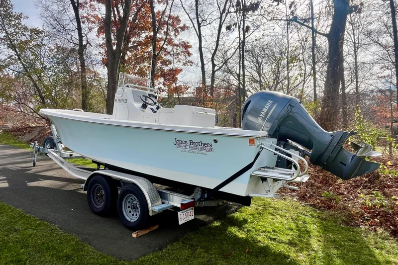 Slide: The Image of 2023 Jones Brothers 23 Cape Fisherman Lite Tackle boat on trailer in wooded area. - 28