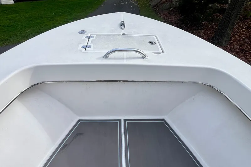 Slide: The Image of 2023 Jones Brothers 23 Cape Fisherman Lite Tackle boat deck, featuring storage hatch and railing. - 7
