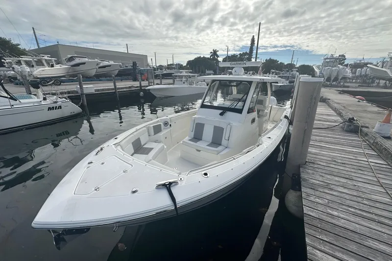 Slide: The Image of 2023 Pursuit S 328 Sport boat docked at marina under cloudy sky. - 5