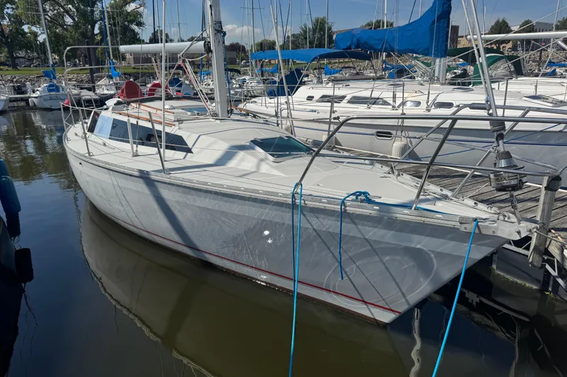 The Image of 1987 O'Day 322 sailboat docked in a marina, surrounded by other boats. - 1