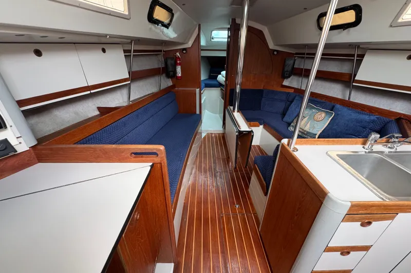 Slide: The Image of Interior of a 1987 O'Day 322 sailboat with wood finish and blue seating. - 14