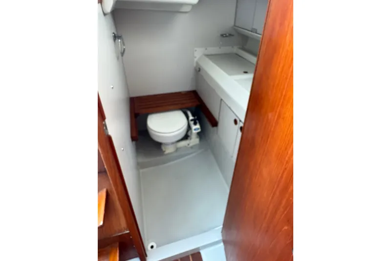 Slide: The Image of 1987 O'Day 322 yacht bathroom with toilet, sink, and wooden accents. - 18