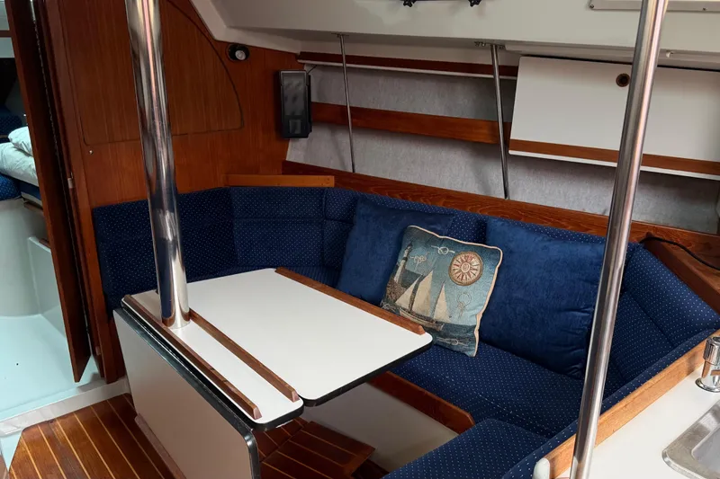Slide: The Image of Interior of a 1987 O'Day 322 sailboat with blue seating and nautical-themed decor. - 23