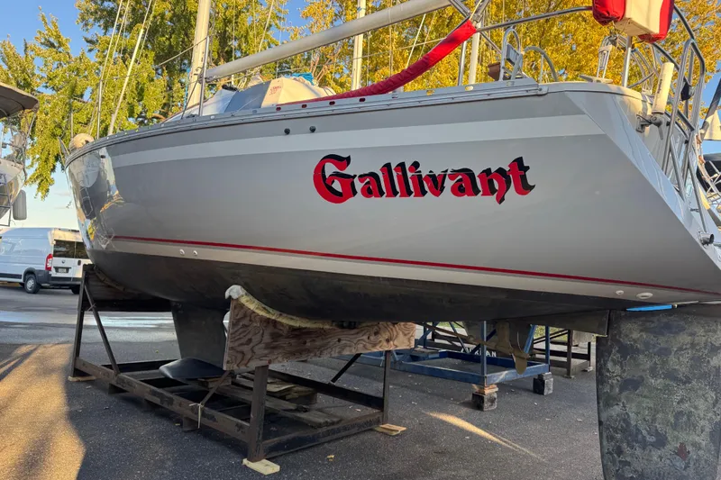 Slide: The Image of 1987 O'Day 322 sailboat named "Gallivant" on a stand, with trees in the background. - 3