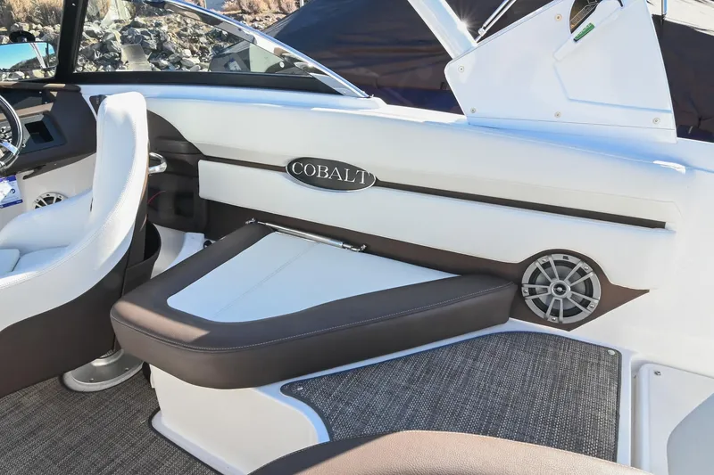 Slide: The Image of 2023 Cobalt CS22 boat interior with white and brown seating, speaker, and steering wheel. - 16