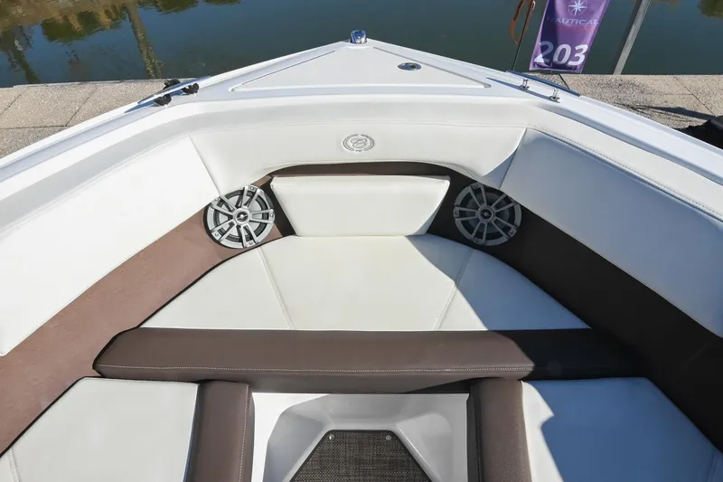 Slide: The Image of 2023 Cobalt CS22 boat interior with white and brown seating, speakers, and water view. - 34