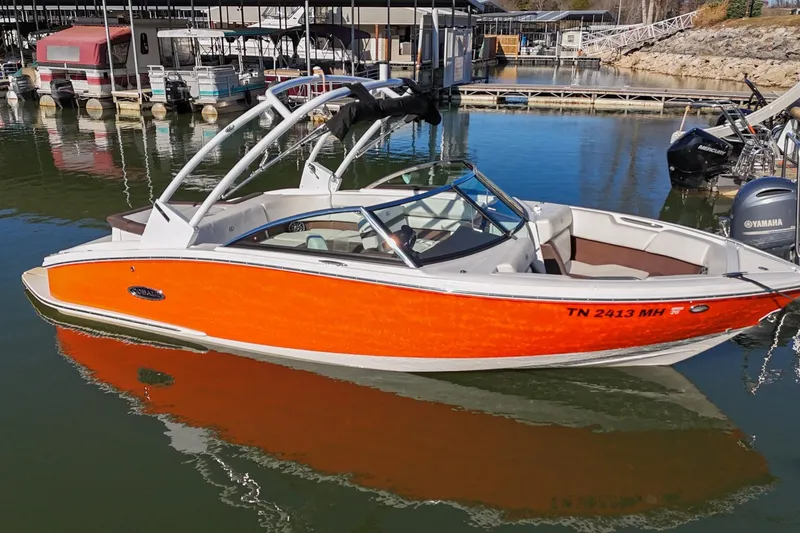 Slide: The Image of 2023 Cobalt CS22 boat with orange hull docked in marina. - 5