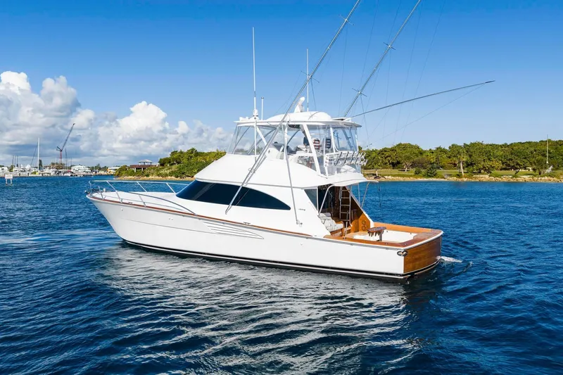 Slide: The Image of 2025 Viking 58 Convertible yacht cruising on a sunny day, with clear blue skies. - 11