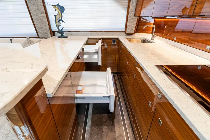 Slide: The Image of Luxurious kitchen interior of 2025 Viking 58 Convertible yacht with marble countertops and wooden cabinetry. - 46