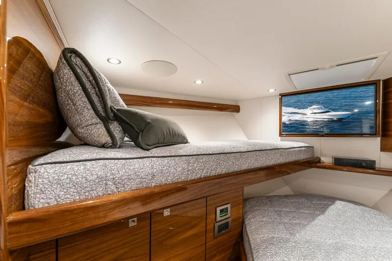 Slide: The Image of Luxurious cabin interior of 2025 Viking 58 Convertible yacht with modern bedding and TV. - 62