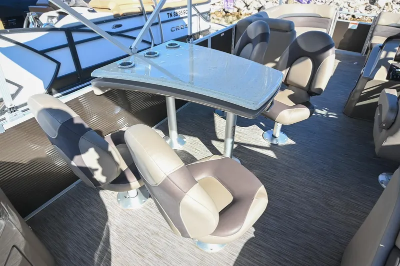 Slide: The Image of 2021 Bennington SX 23 Entertainment boat interior with seating and table setup. - 11