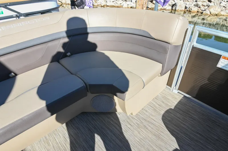 Slide: The Image of 2021 Bennington SX 23 Entertainment boat interior with beige seating and speaker. - 23