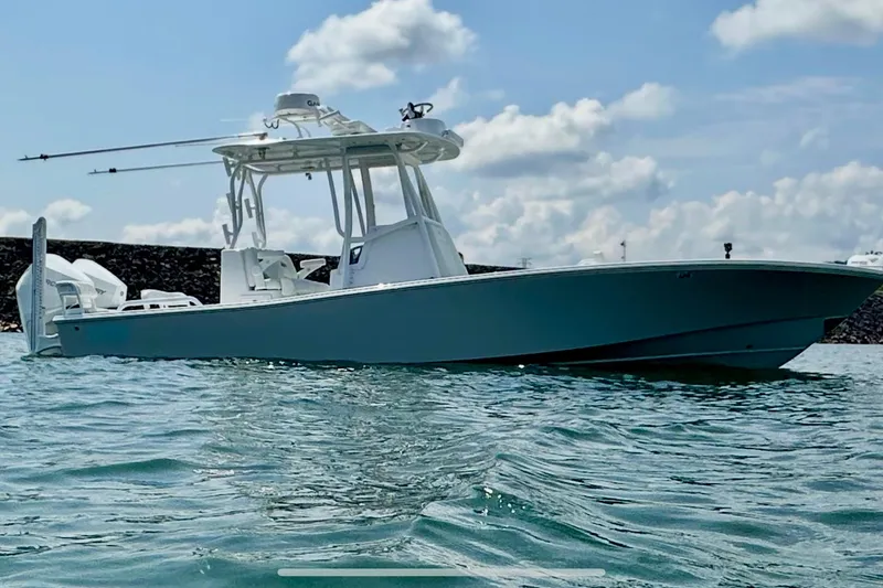 Slide: The Image of 2024 ZCB Freemason 26 Open boat on trailer, parked near coastal buildings. - 0