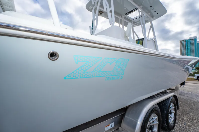 Slide: The Image of 2024 ZCB Freemason 26 Open boat on trailer, showcasing sleek design and logo. - 18