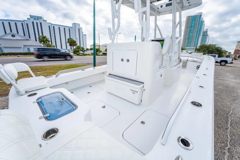 Slide: The Image of 2024 ZCB Freemason 26 Open boat interior with seating and storage, parked near buildings. - 25