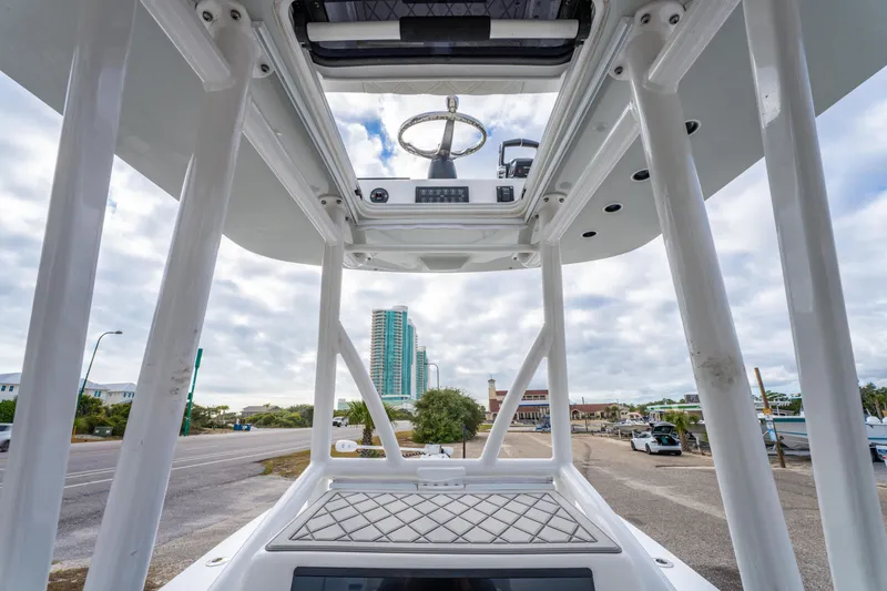 Slide: The Image of 2024 ZCB Freemason 26 Open boat, view from helm, urban backdrop, cloudy sky. - 34