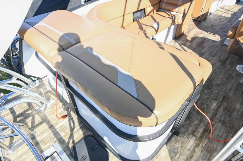 Slide: The Image of 2023 Crest Caribbean LX 250 boat interior with tan seating and wood-style flooring. - 12