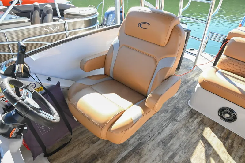 Slide: The Image of 2023 Crest Caribbean LX 250 boat interior with luxurious captain's chair and steering wheel. - 21