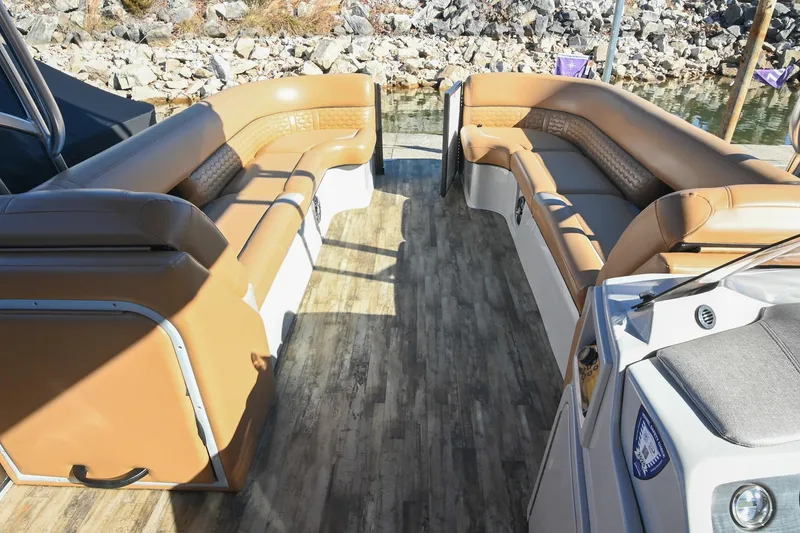 Slide: The Image of 2023 Crest Caribbean LX 250 boat interior with tan seating and wood-style flooring. - 23