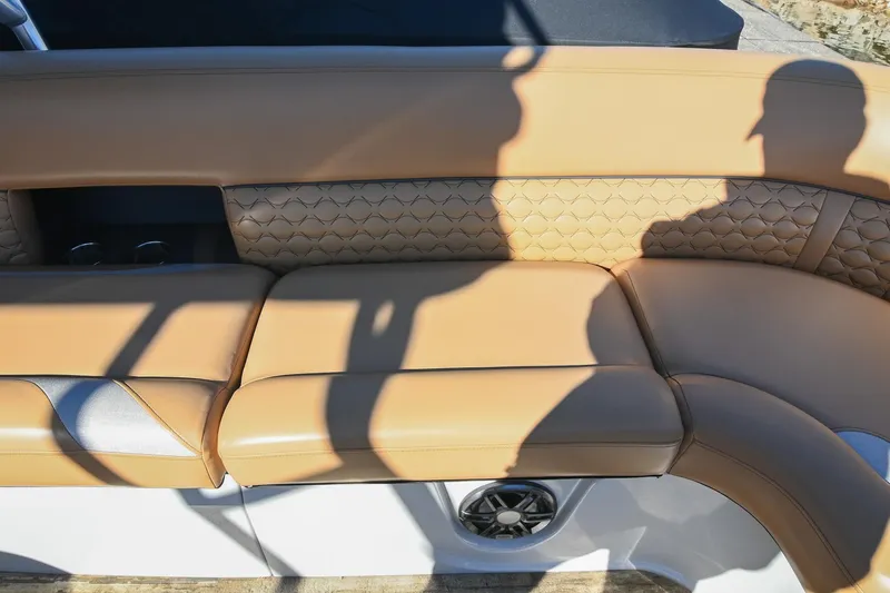 Slide: The Image of 2023 Crest Caribbean LX 250 boat interior with tan leather seating and speaker. - 26