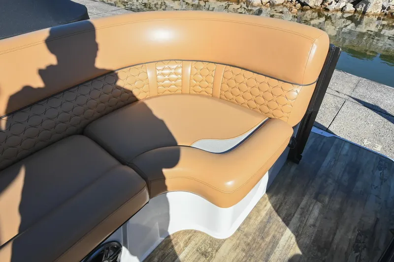 Slide: The Image of Luxurious tan seating on 2023 Crest Caribbean LX 250 boat, with quilted design and waterfront view. - 27